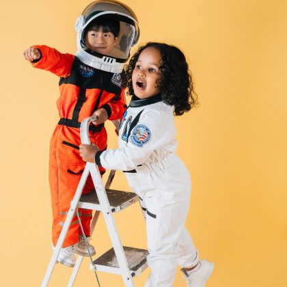 Niños vestidos de astronautas sobre una escalera